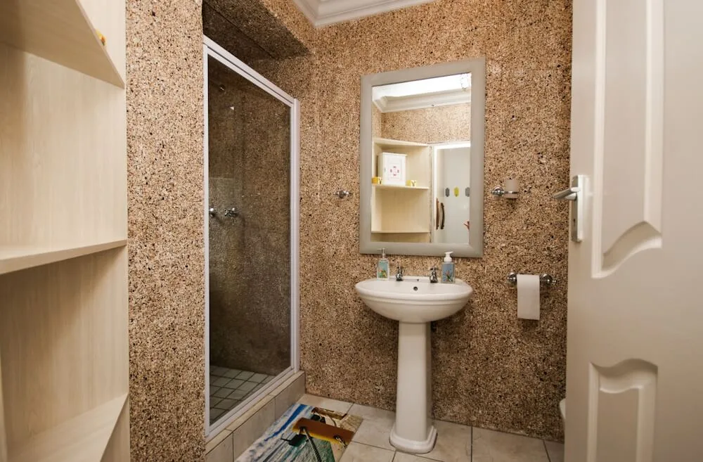 En-suite bathroom with glass shower cubicle and pedestal sink, Unit Two, Die Hawehuis