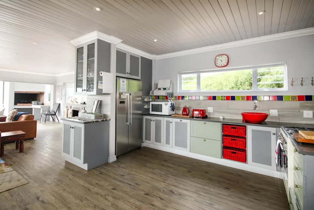 Kitchen with stainless steel fridge, white oven and colourful tiled splashback, Unit Two, Die Hawehuis